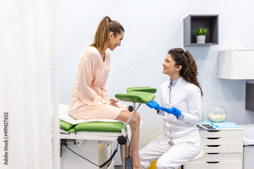Gynecologist talking with young female patient during medical consultation in modern clinic. Patient with a gynecologist during the consultation in the gynecological office photo