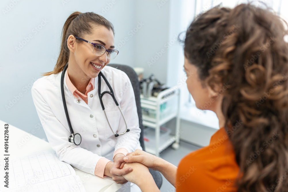 Young woman doctor or GP in white medical uniform consult female patient in private hospital. Female therapist speak talk with woman client on consultation in clinic. Young woman doctor or GP in white medical uniform consult female patient in private hospital. Female therapist speak talk with woman client on consultation in clinic.