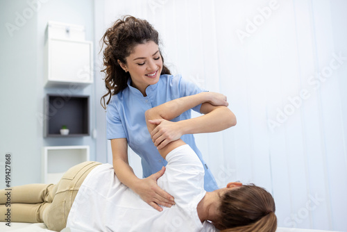 Physiotherapist treatment patient. Holding patient's hand, shoulder joint treatment. Physical Doctor consulting with patient About Shoulder muscule pain problems Physical therapy diagnosing concept photo