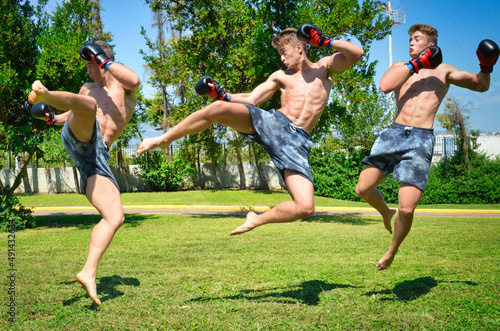 Muscle Athletic Man Jumping and doing martial arts moves and training out in nature. © Nicholas Ar