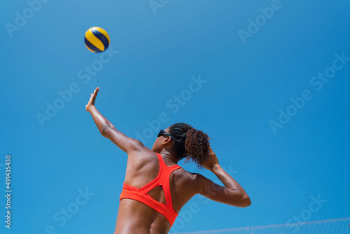 Woman with afro hair playing beach volleyball