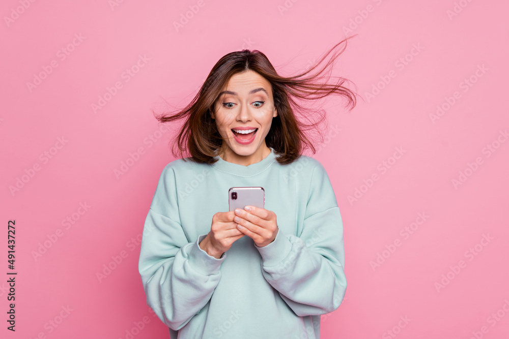 Photo of young cheerful lovely girl look chat smartphone share comment isolated over pink color background Photo of young cheerful lovely girl look chat smartphone share comment isolated over pink color background