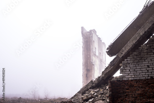Print op canvas The ruined remains of a building with a pile of concrete rubble and bricks in a hazy haze
