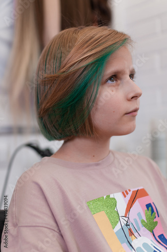 Teenage girl with colored green hair in a bob hairstyle