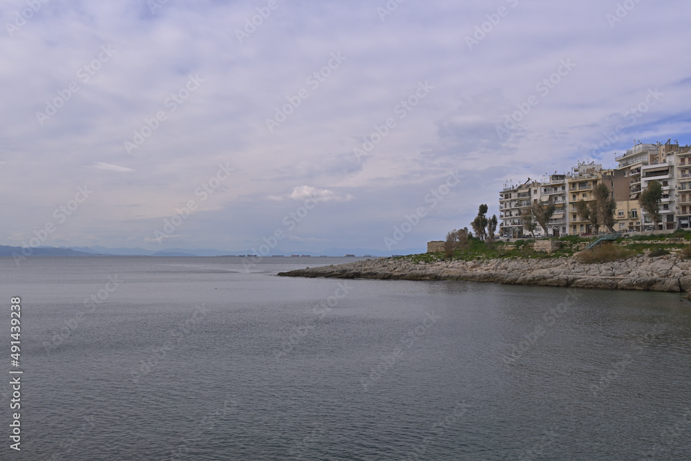 View of the coast of the city of Piraeus with commercial broads in the sea.