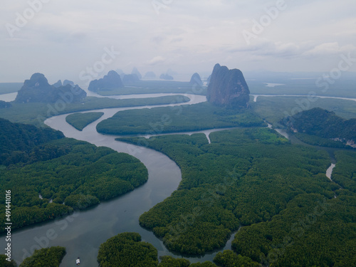 Top and aerial view in area of NAI HGOP pier of Ao Phang - Nga in Thailand show line of water with mangroves along the sides and cloudy sky in evening look like raining.