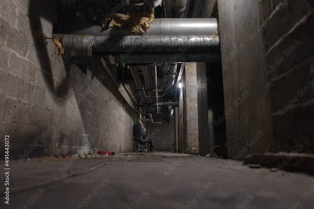 View of a basement with a woman sitting on a bench and reading a war news View of a basement with a woman sitting on a bench and reading a war news