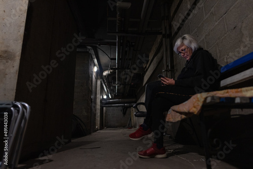 Woman is sitting on a bench and reading a war news in a bomb-shelter