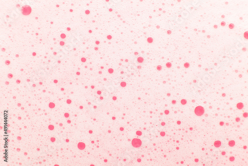 Pink soap foam. Shampoo bubbles on the water, close-up.