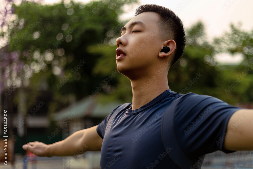 Sports and recreation concept a male adolescent doing warm-up movements as raising his body temperature and increasing blood flow to his muscles Sports and recreation concept a male adolescent doing warm-up movements as raising his body temperature and increasing blood flow to his muscles