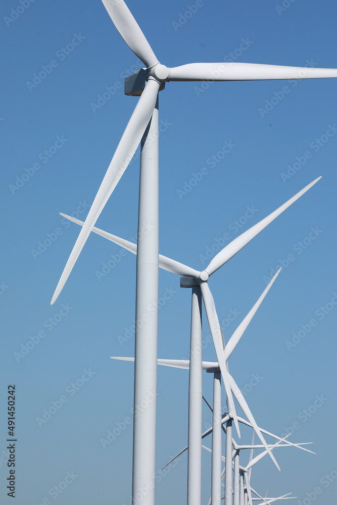 A row of windmills against a blue sky
A row of windmills against a blue sky