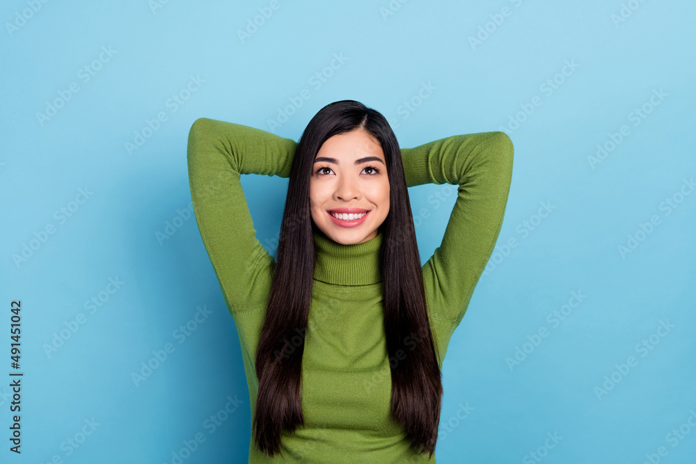 Photo of funky millennial brunette lady look up wear green pullover isolated on blue color background Photo of funky millennial brunette lady look up wear green pullover isolated on blue color background