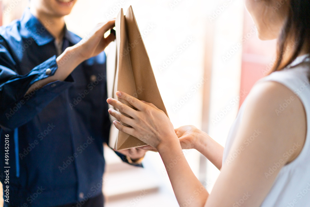 Obraz premium フードデリバリーを受け取る若い女性