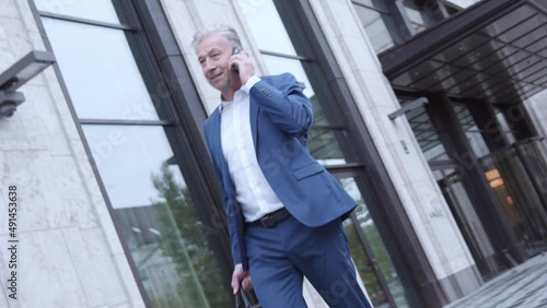 Wallpaper Mural Mature businessman leaving building talking on the phone Torontodigital.ca
