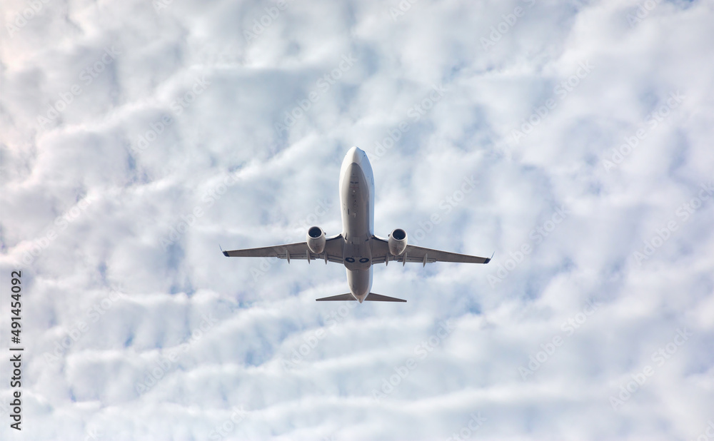 White passenger airplane flying in the sky amazing clouds in the background - Travel by air transport White passenger airplane flying in the sky amazing clouds in the background - Travel by air transport