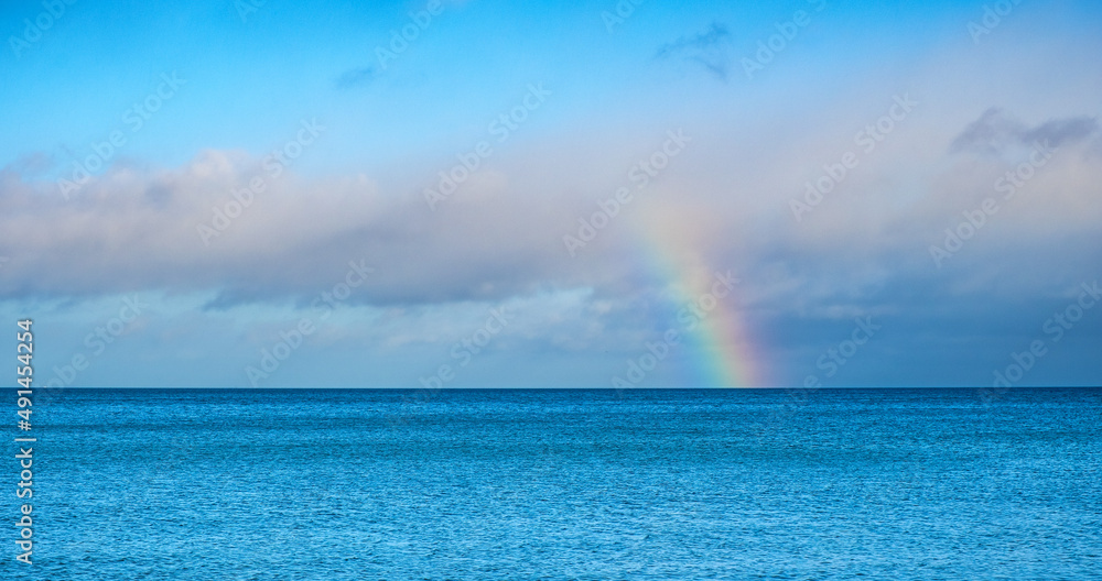 Panoramic winter view of Baltic sea with gulls on water surface with rainbow over maritime horizon offshore Gdynia Orlowo district of Tricity in Pomerania region of Poland