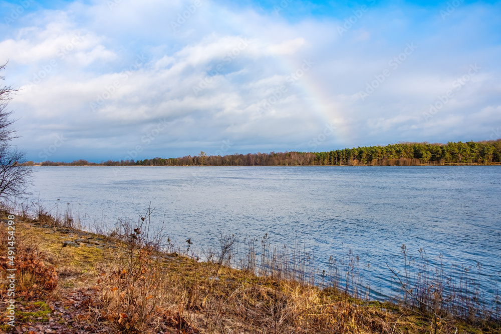 Winter landscape of Vistula river estuary to Baltic Sea with rainbow aside Gull Sandbank - Mewia Lacha - wildlife reserve on Wyspa Sobieszewska Island near Gdansk in Poland