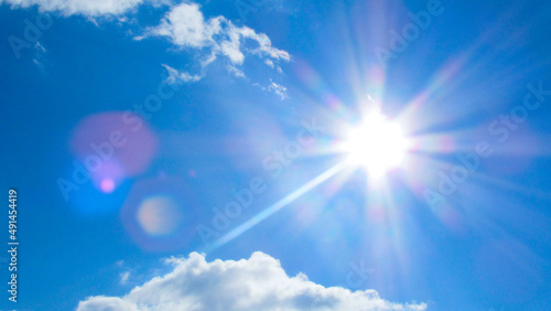 sun on the background of a blue sky with white clouds