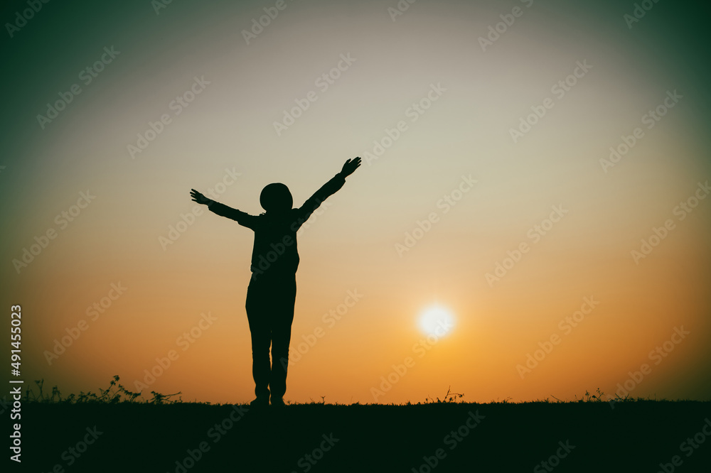 Silhouette of the woman standing lonely at the river during beautiful sunset