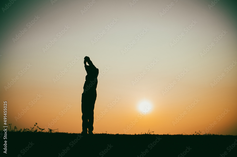 Silhouette of the woman standing lonely at the river during beautiful sunset Silhouette of the woman standing lonely at the river during beautiful sunset