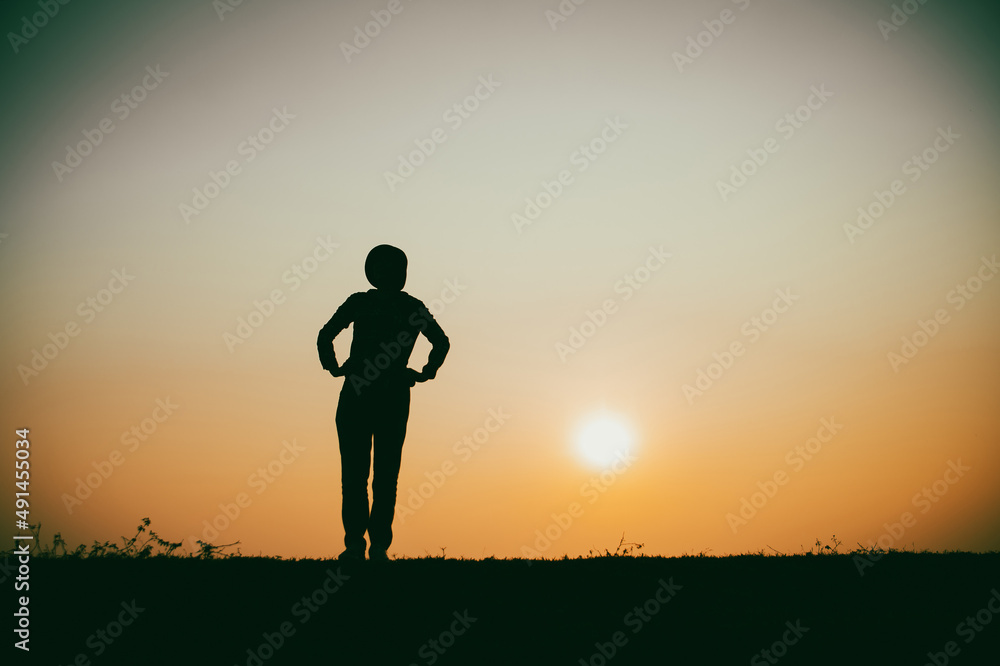 Silhouette of the woman standing lonely at the river during beautiful sunset Silhouette of the woman standing lonely at the river during beautiful sunset