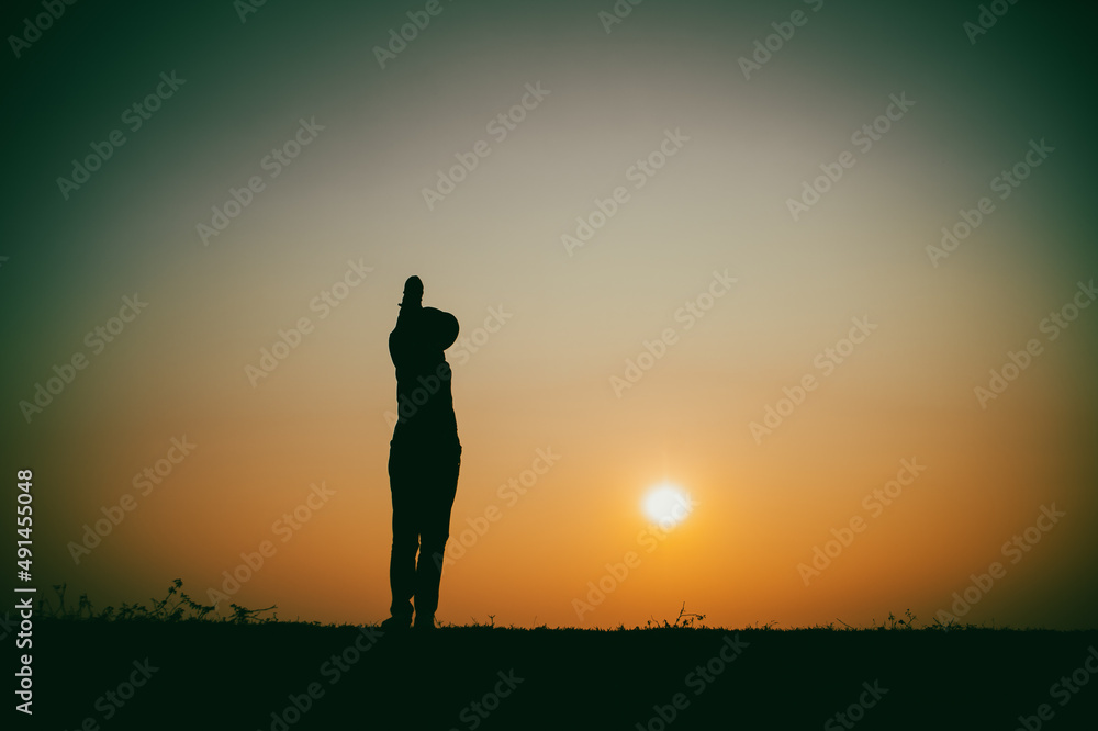 Silhouette of the woman standing lonely at the river during beautiful sunset Silhouette of the woman standing lonely at the river during beautiful sunset