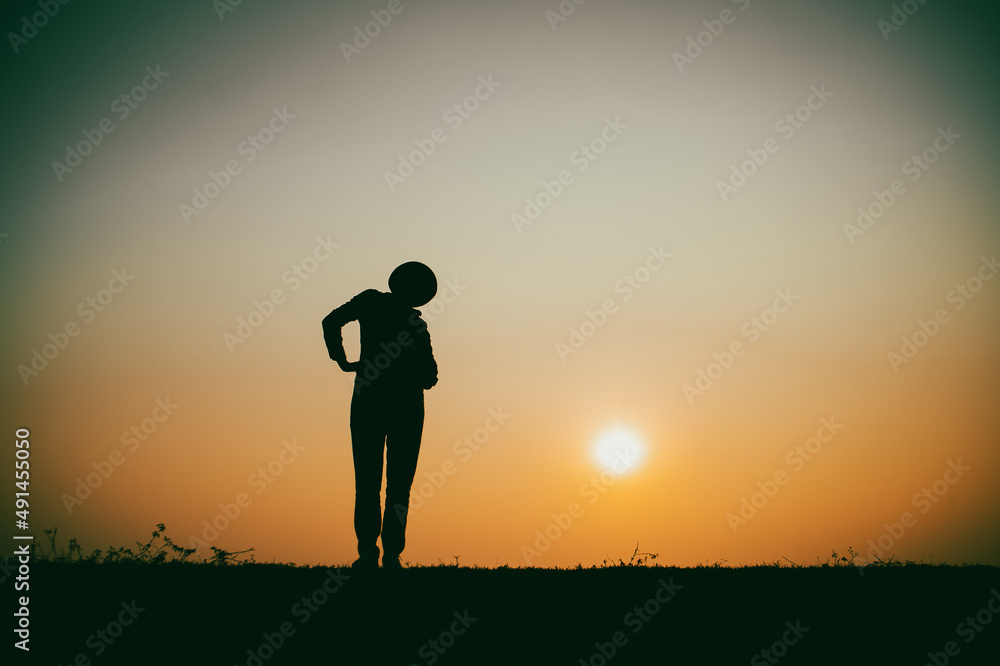 Silhouette of the woman standing lonely at the river during beautiful sunset Silhouette of the woman standing lonely at the river during beautiful sunset