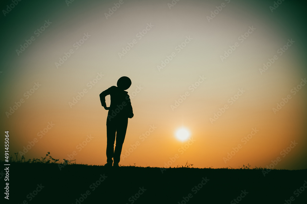 Silhouette of the woman standing lonely at the river during beautiful sunset