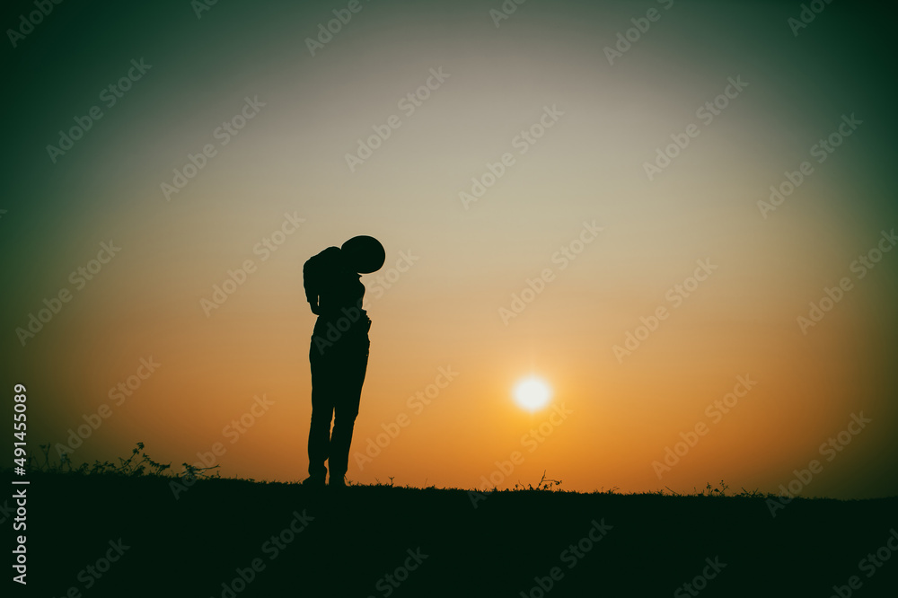 Silhouette of the woman standing lonely at the river during beautiful sunset