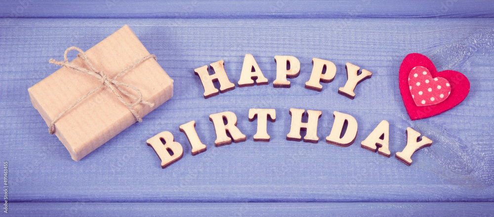 Inscription happy birthday and wrapped gift with ribbon and heart on boards. Vintage photo Inscription happy birthday and wrapped gift with ribbon and heart on boards. Vintage photo