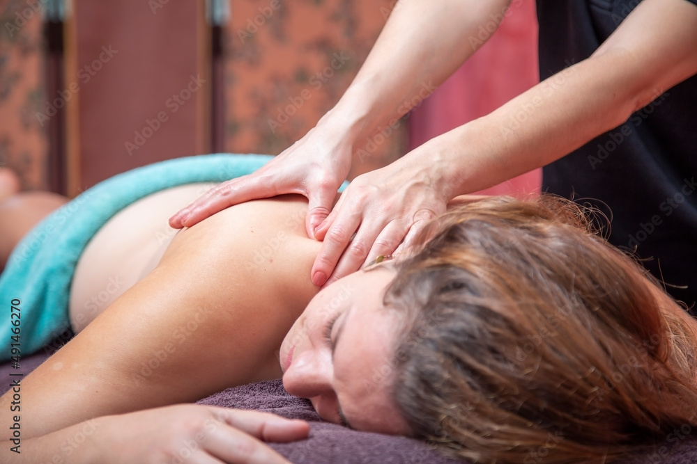 Woman massaging back of client in salon Woman massaging back of client in salon