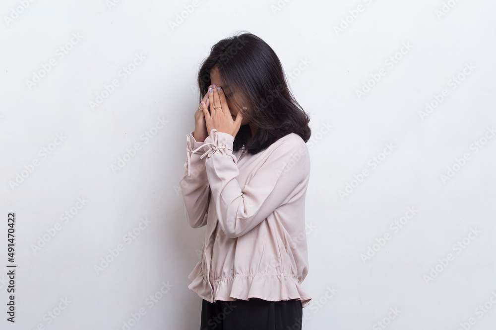 Asian beautiful young woman covers her face with her hands on white background
Asian beautiful young woman covers her face with her hands on white background
