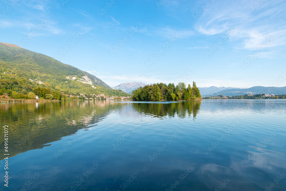Lake of Pusiano, Italy. In the center the Isola dei Cipressi (Cypress Island) and on the left the town of Pusiano . Natural lake between the cities of Como and Lecco  