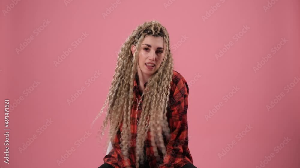 A cute girl with curls moves rhythmically while sitting on a chair A cute girl with curls moves rhythmically while sitting on a chair