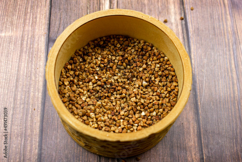Buckwheat natural. A grain of buckwheat. Buckwheat in a wooden jar. Buckwheat and palms.