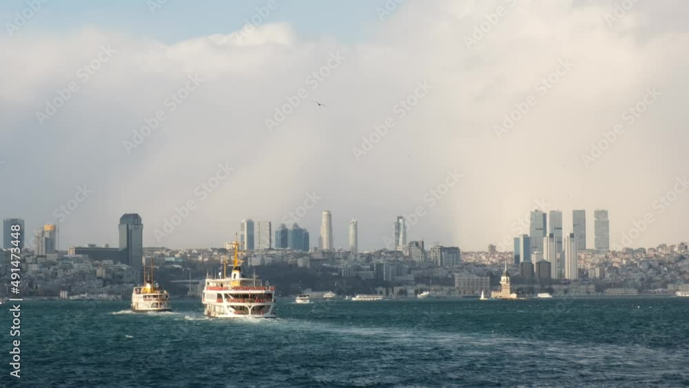Two ferry boats are carrying passengers on The Istanbul Bosphorus on a sunny day. The urban skyline in the background is looking awesome. Two ferry boats are carrying passengers on The Istanbul Bosphorus on a sunny day. The urban skyline in the background is looking awesome.