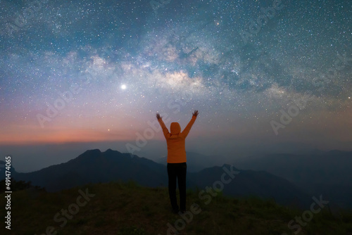 Portrait of Asian woman, a tourist, travel at Doi Tung, Chiang Rai, Thailand with mountain hills, the milky way in galaxy with stars at night. Universe space landscape background. People lifestyle.
