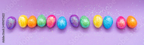 Multi-colored Easter eggs on a purple background. Holiday concept with copy space.