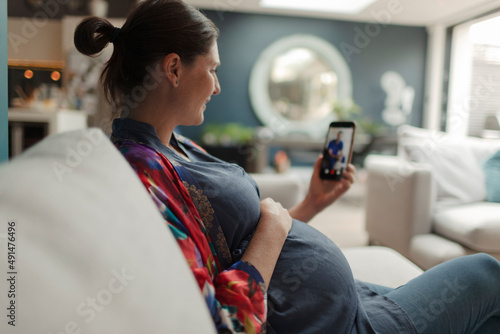Pregnant woman video chatting with doctor on smart phone photo