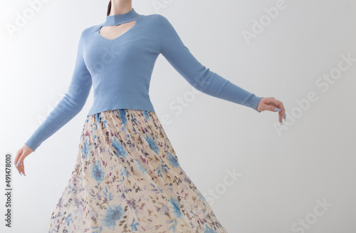 young girl in blue blouse  and pleated skirt on white background