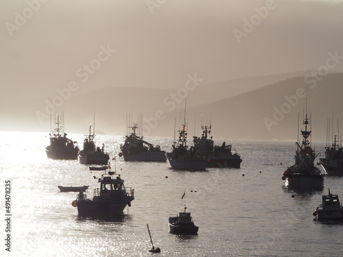 bonito amanecer cayendo sobre el puerto pesquero de malpica con los barcos de pesca saliendo al alba. la coruña, españa, europa 