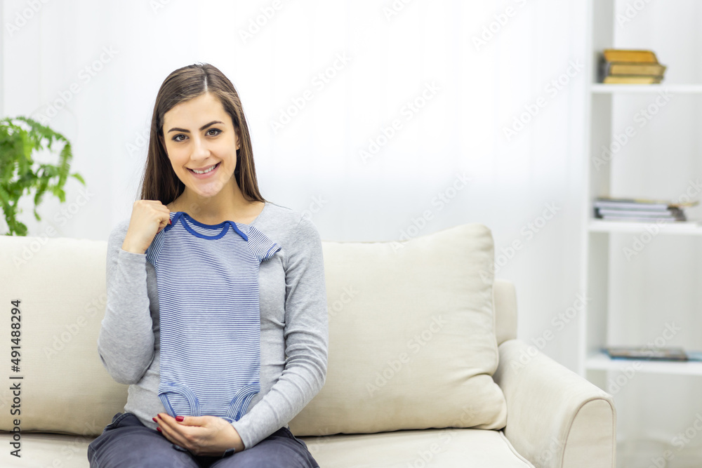 Photo of pregnant woman holding child small clothes. Photo of pregnant woman holding child small clothes.
