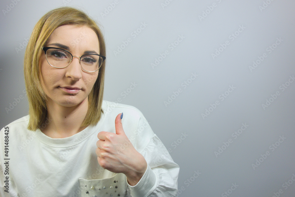 Young beautiful blond woman wearing casual shirt on isolated background doing happy thumbs up sign. Approving expression, success concept Young beautiful blond woman wearing casual shirt on isolated background doing happy thumbs up sign. Approving expression, success concept