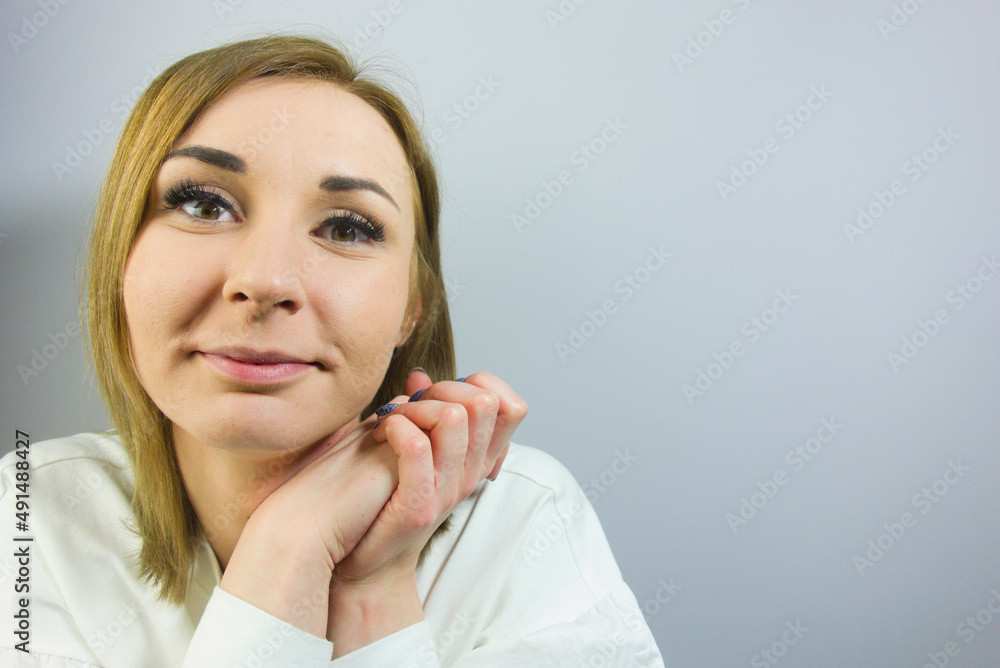 Closeup photo of young blond lady deep thinking or daydreaming wearing casual white shirt isolated on gray background Closeup photo of young blond lady deep thinking or daydreaming wearing casual white shirt isolated on gray background