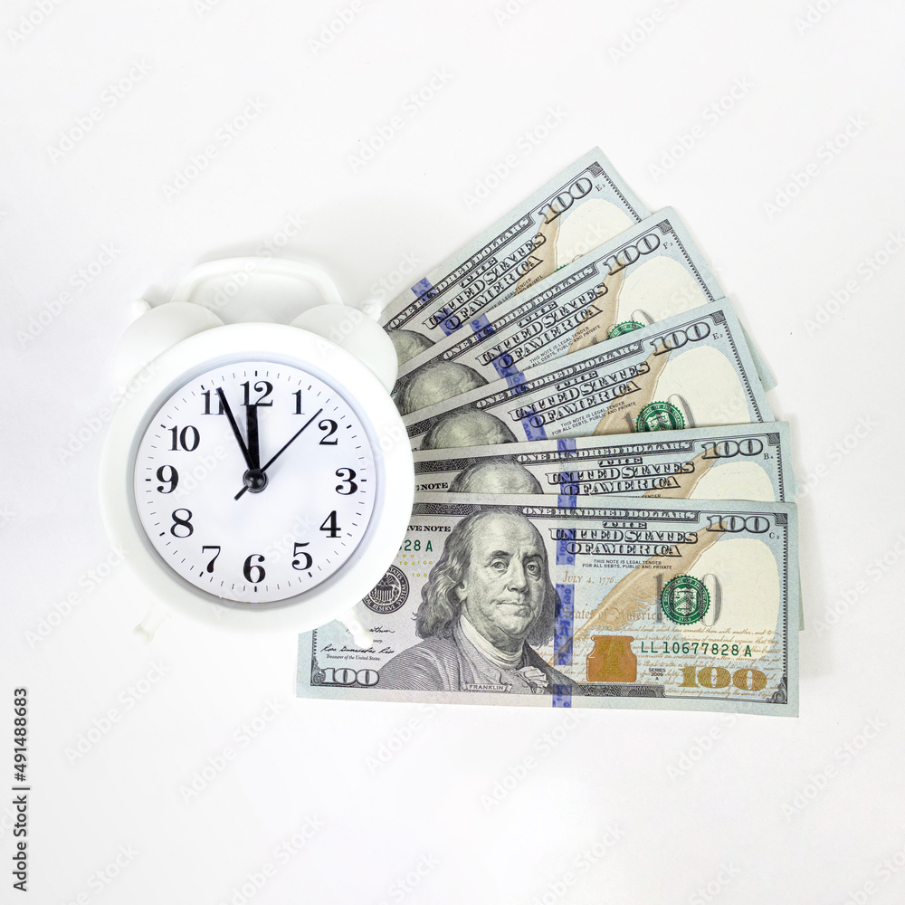 Time is money. Gray alarm clock on money banknotes Dollars. Finance and business