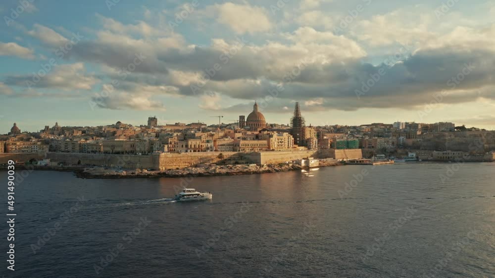 Valletta city, capital of Malta. Sunset, aerial view, main church, dome, evening, sea, boat Valletta city, capital of Malta. Sunset, aerial view, main church, dome, evening, sea, boat