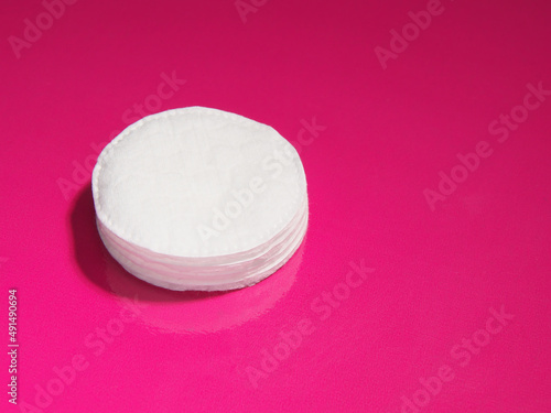 cotton pads, on a pink background, copy space.