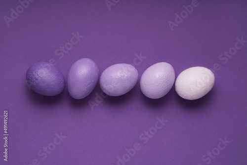 Purple colored Easter eggs on very peri purple background. Creative minimal concept. Pastel colors and soft shadows.