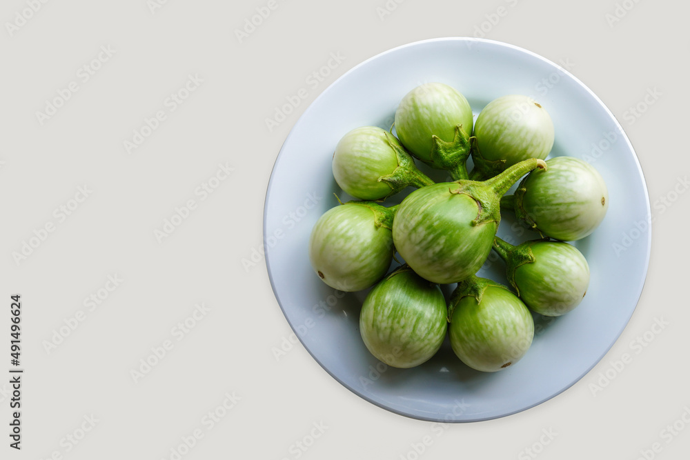 top view fresh nine solanum melongena vegetable on white dish on white background, vegetable, health, food, copy space