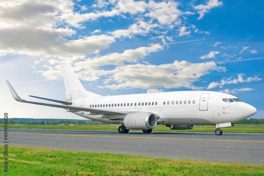 Commercial liner taxis on the steering track against the background of the sky and clouds. Commercial liner taxis on the steering track against the background of the sky and clouds.